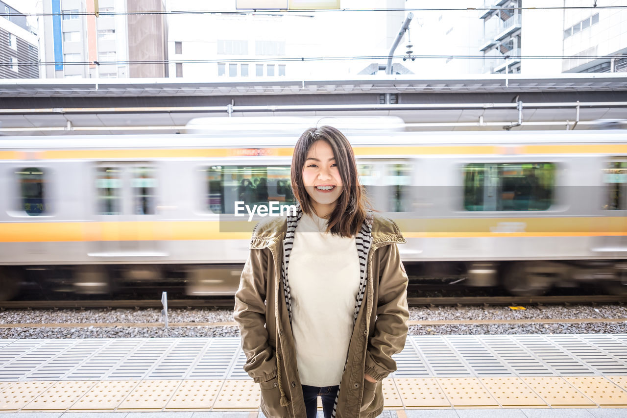 Full length of beautiful woman standing at railroad station