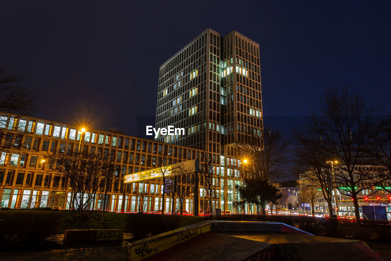 illuminated buildings against sky at night