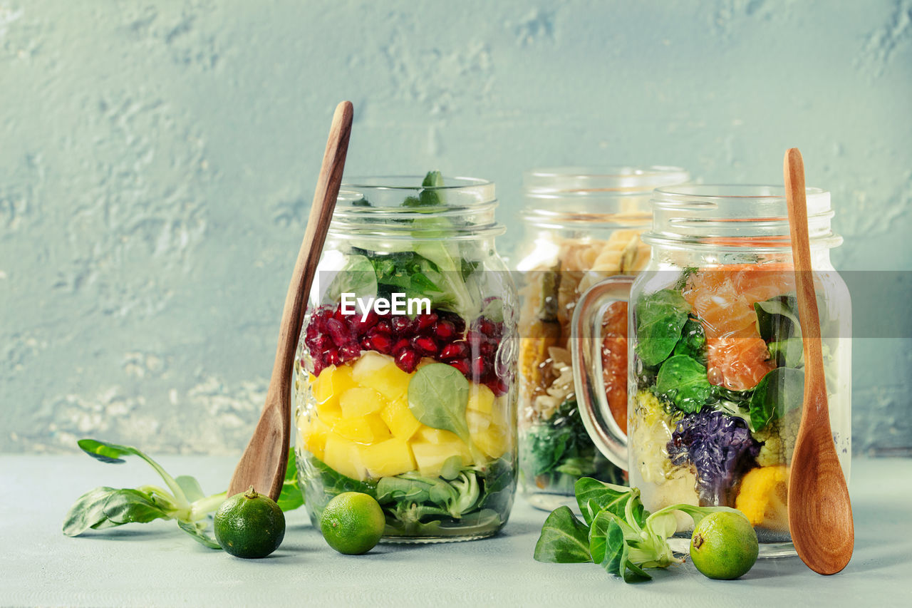 CLOSE-UP OF FRUITS AND VEGETABLES ON TABLE AGAINST WALL