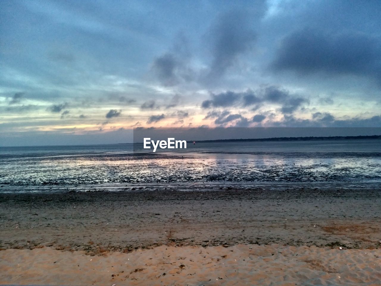 SCENIC VIEW OF SEA AGAINST CLOUDY SKY DURING SUNSET