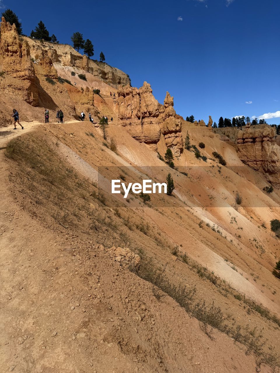 nature, land, sky, scenics - nature, rock, soil, landscape, environment, terrain, beauty in nature, no people, desert, wadi, travel destinations, outdoors, day, geology, travel, non-urban scene, blue, sunlight, rock formation, cliff, tranquility, mountain, tranquil scene, sand, climate, clear sky, extreme terrain, low angle view