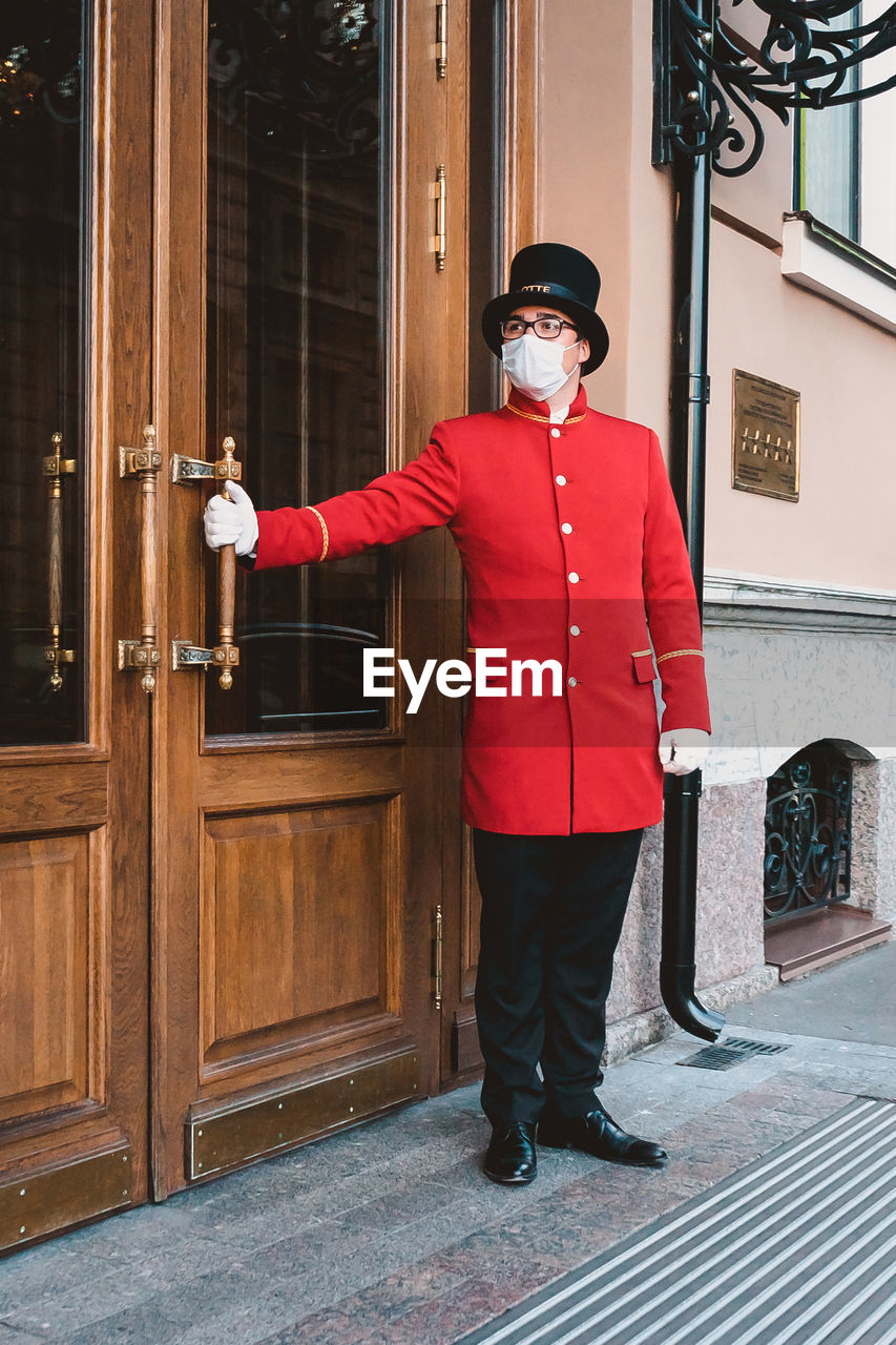 FULL LENGTH PORTRAIT OF MAN STANDING ON DOOR