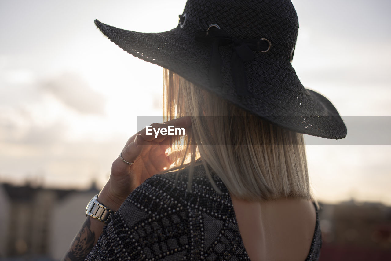 Close-up portrait of woman wearing hat against sky