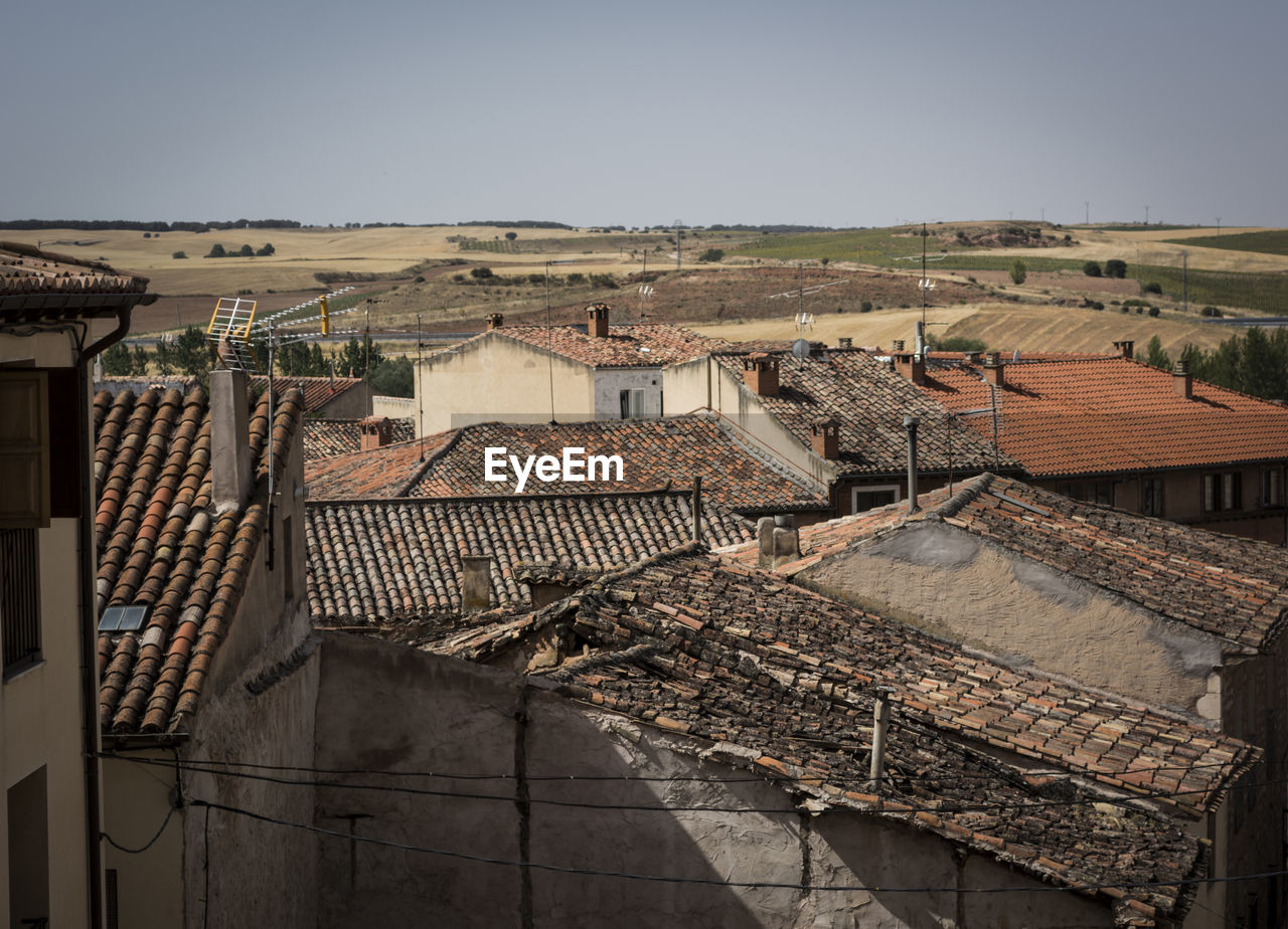 View of tiled roofs against clear sky