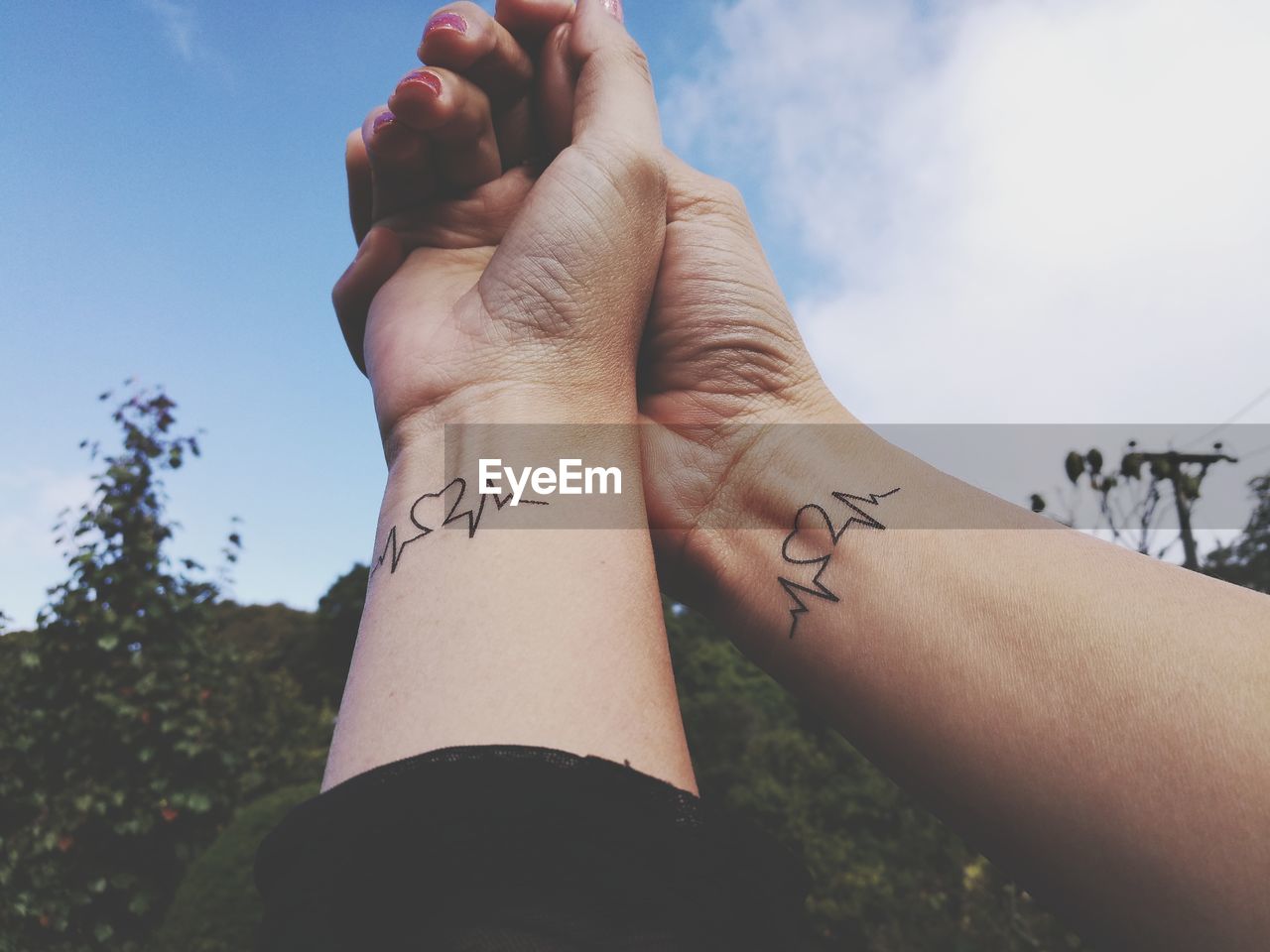 Cropped hand of couple with tattoo