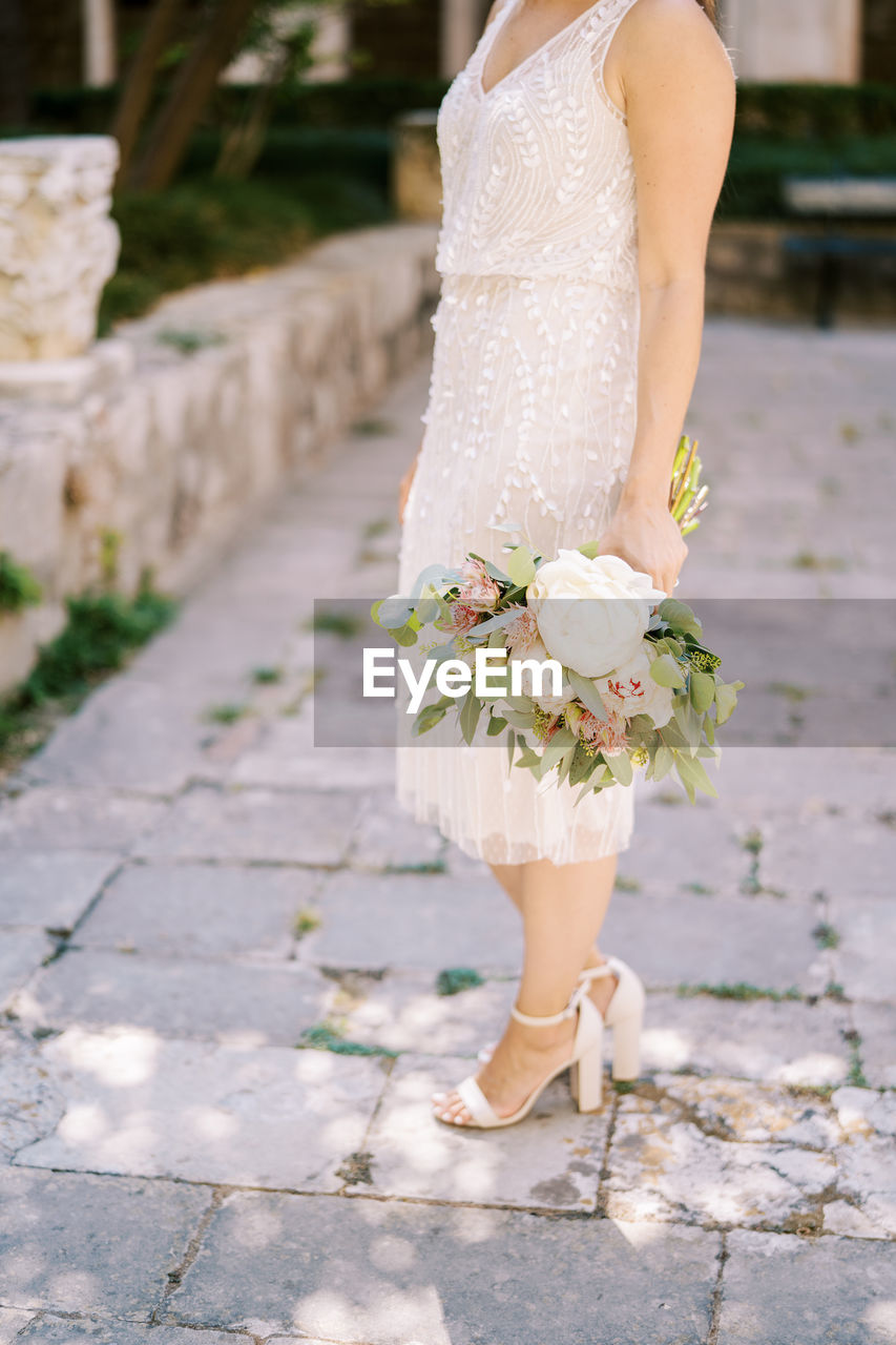 low section of bride standing on footpath