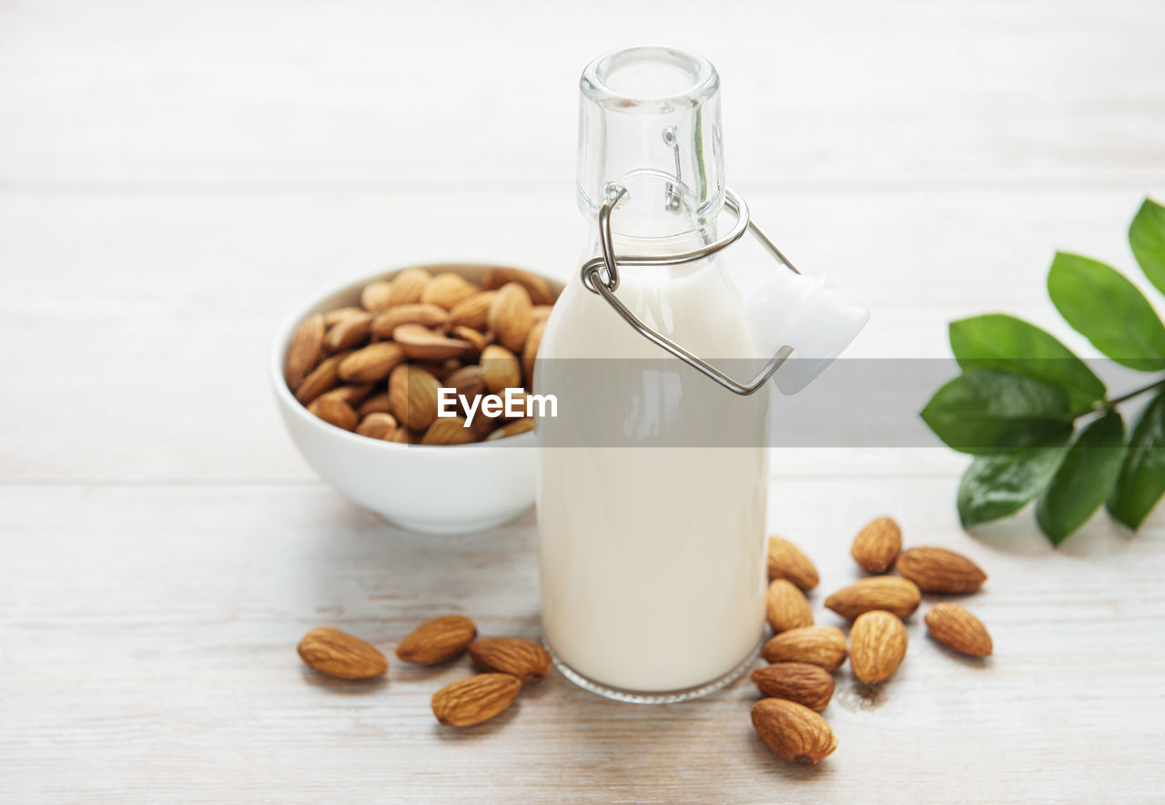 Bottles with almond milk and almonds on the table