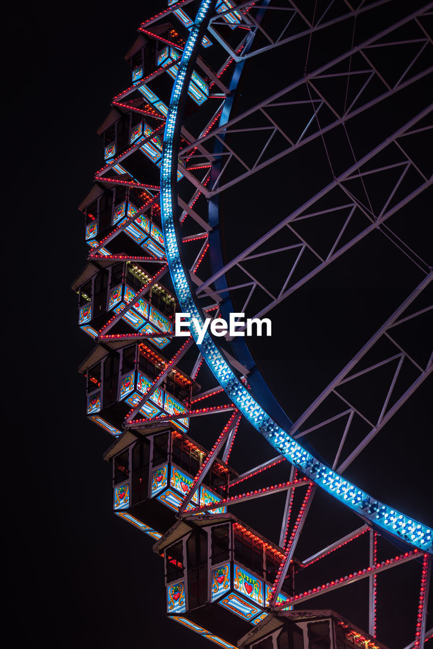 Low angle view of illuminated ferris wheel against sky at night