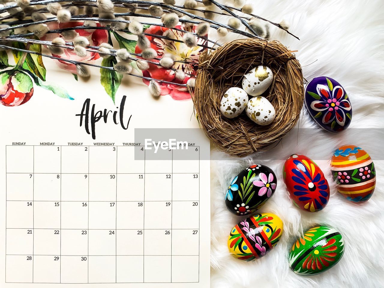 High angle view of colorful easter eggs with calendar on table