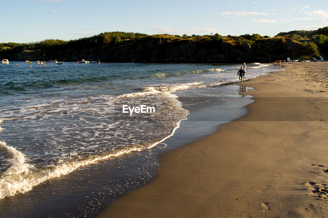 Boys running on shore at beach