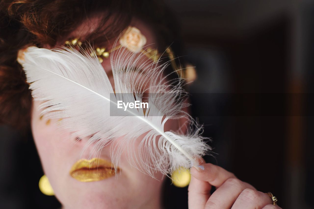 Woman holding a white feather