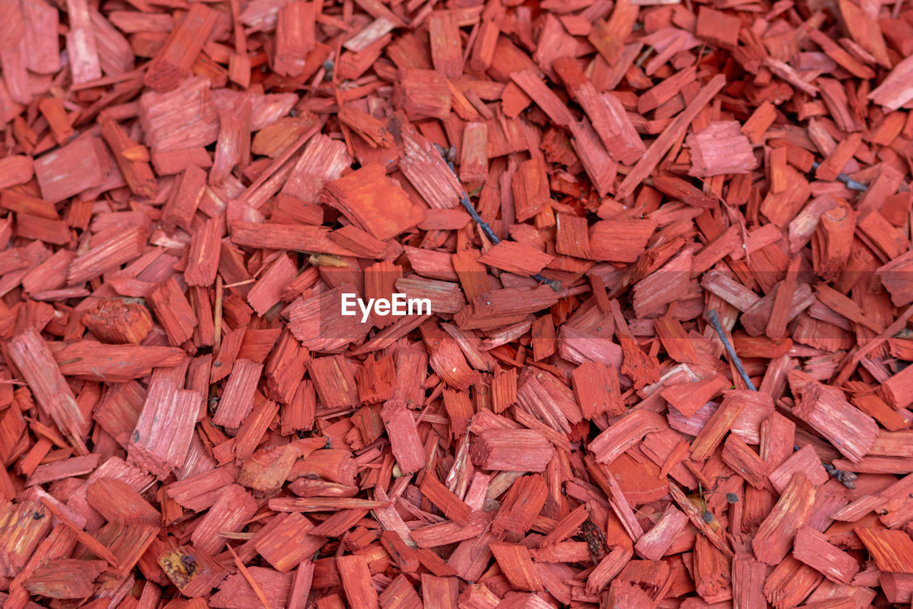 Shredded red wood chips fragments as red woodpath with timber shavings and recycled