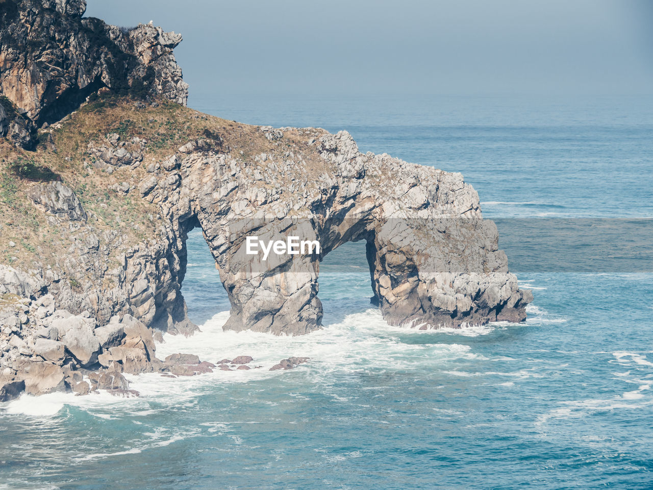 SCENIC VIEW OF ROCKS IN SEA AGAINST CLEAR SKY