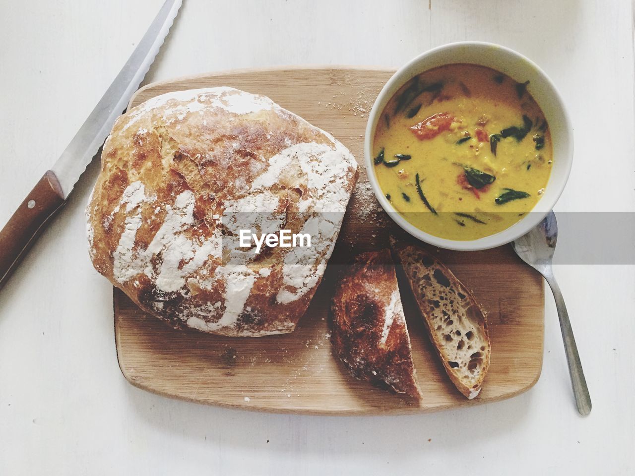 Directly above view of fresh bread and soup on wooden tray