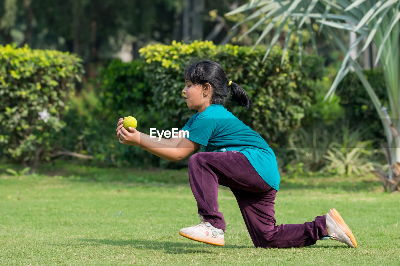 one person, sports, plant, lawn, lifestyles, full length, adult, nature, grass, wellbeing, exercising, green, leisure activity, childhood, side view, child, relaxation, men, casual clothing, outdoors, day, practicing, person, activity, female, women, tree, sports clothing, concentration