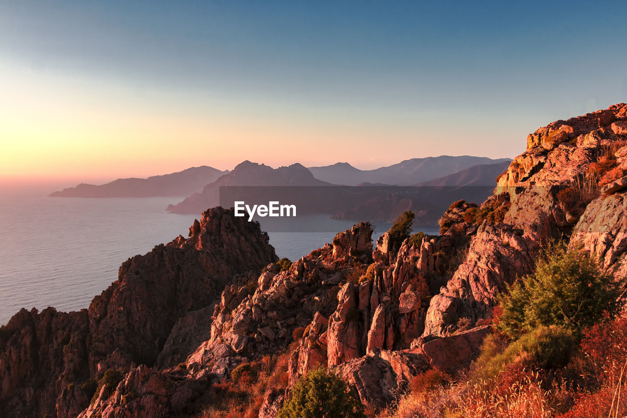 Scenic view of mountains against sky at sunset