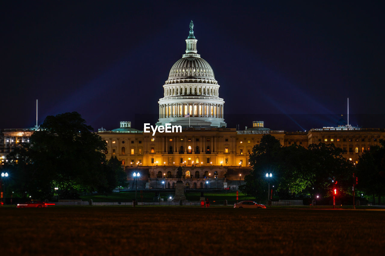 low angle view of illuminated buildings in city at night