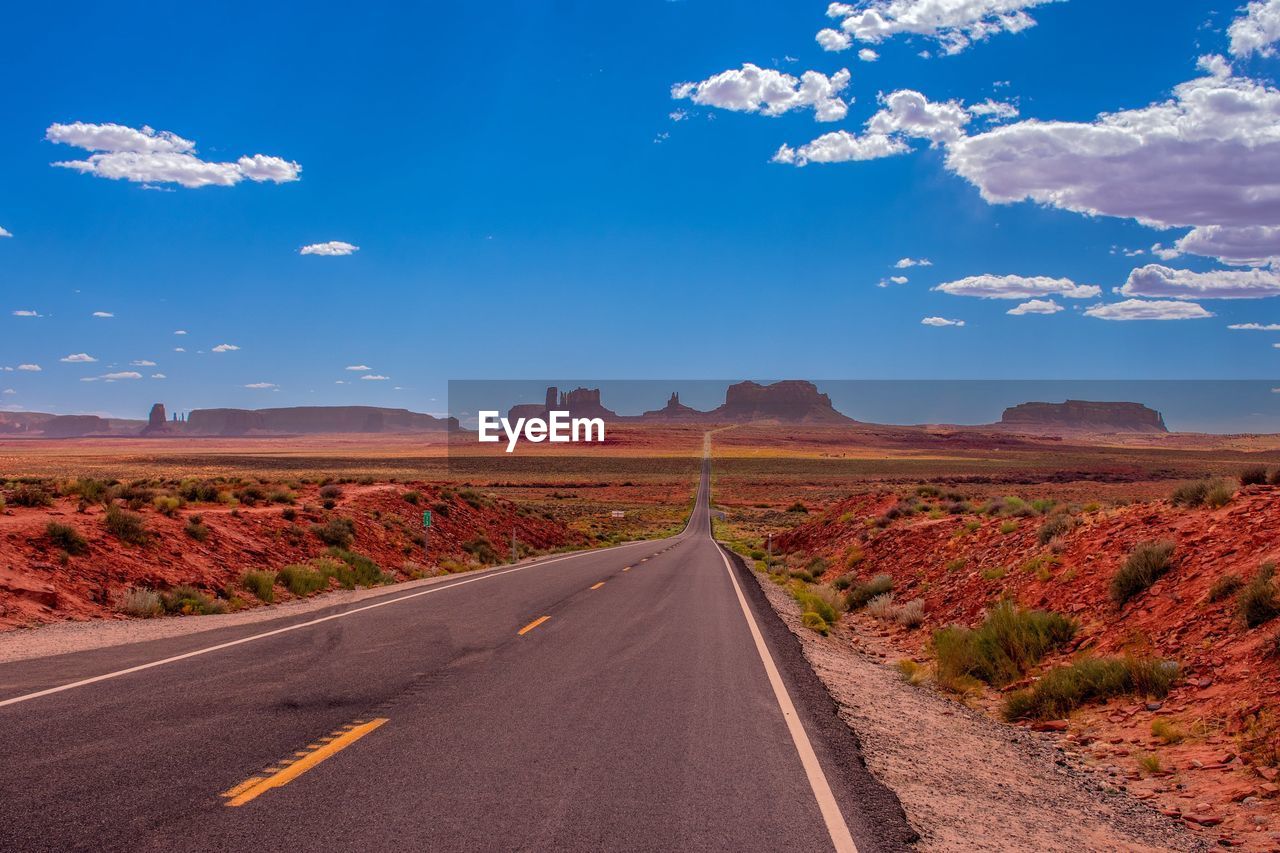 ROAD AMIDST LAND AGAINST SKY