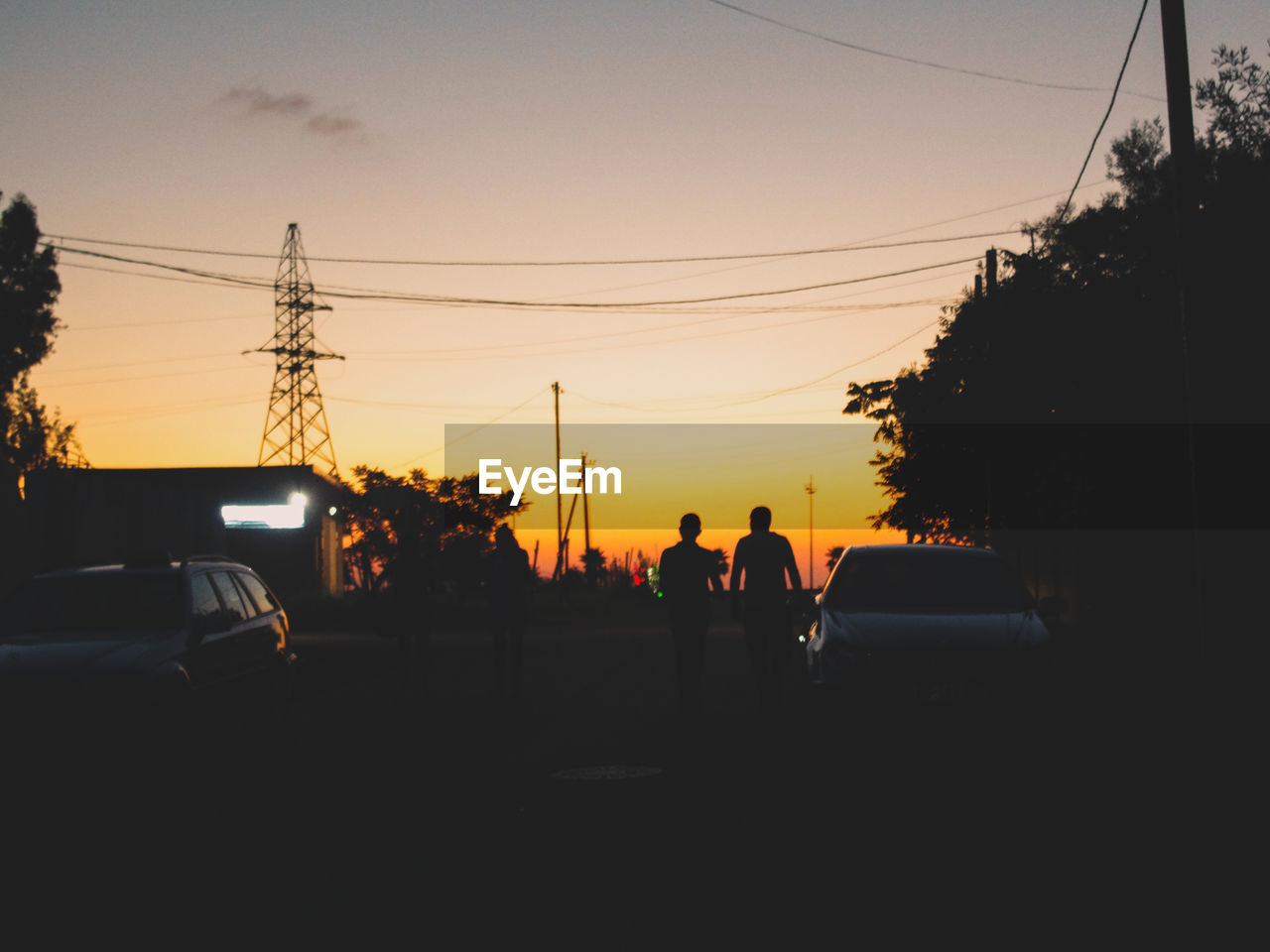 Silhouette of cars on road against sky during sunset