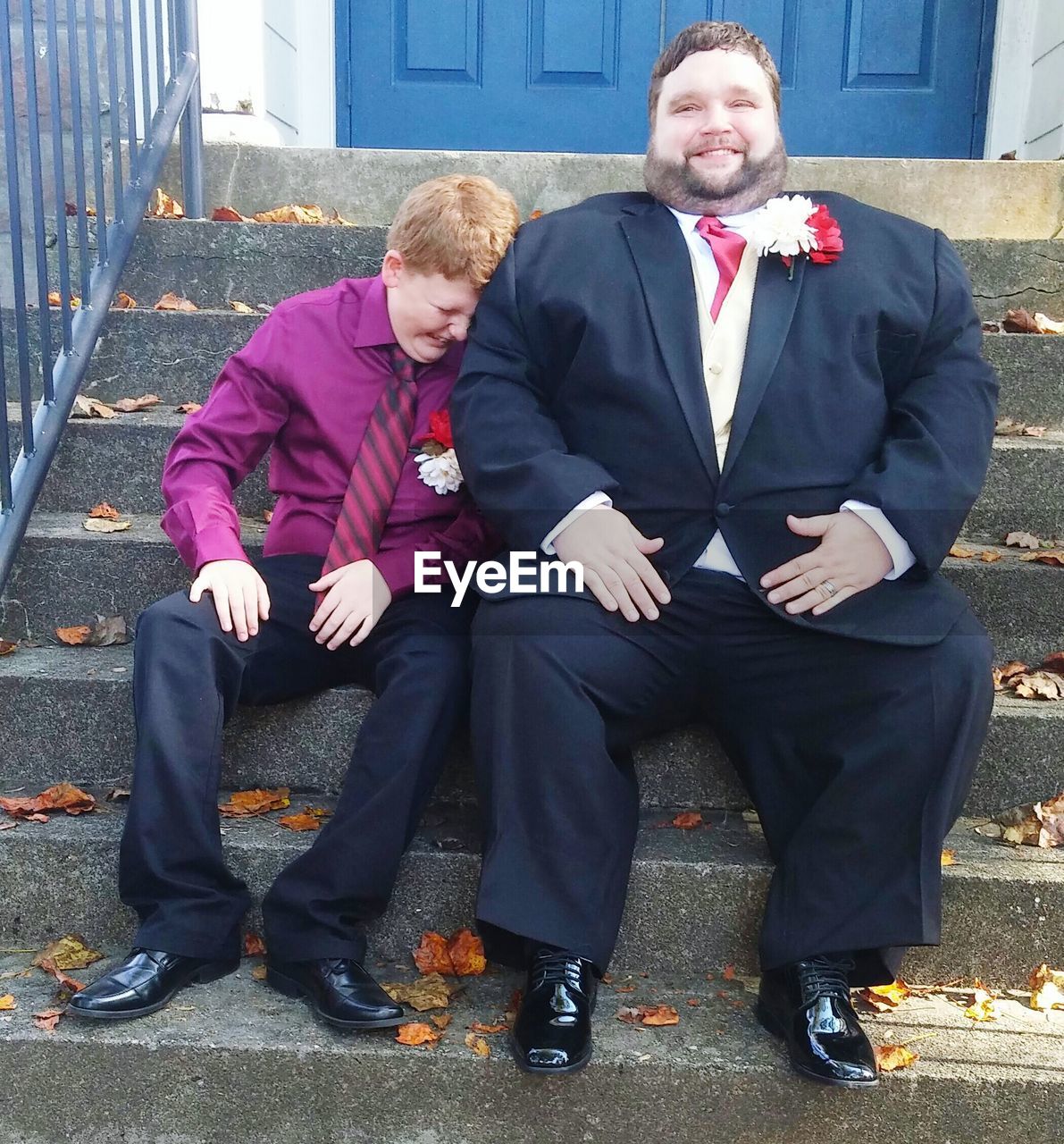 Full length portrait of father with son sitting steps