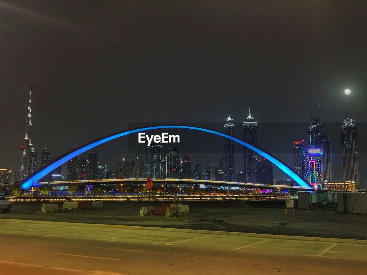 LIGHT TRAILS ON BRIDGE AGAINST BUILDINGS