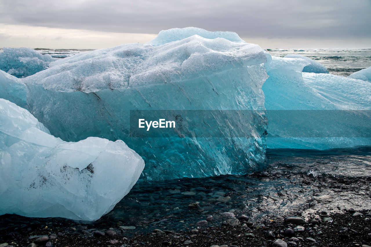 Close-up of glacier on sea against sky