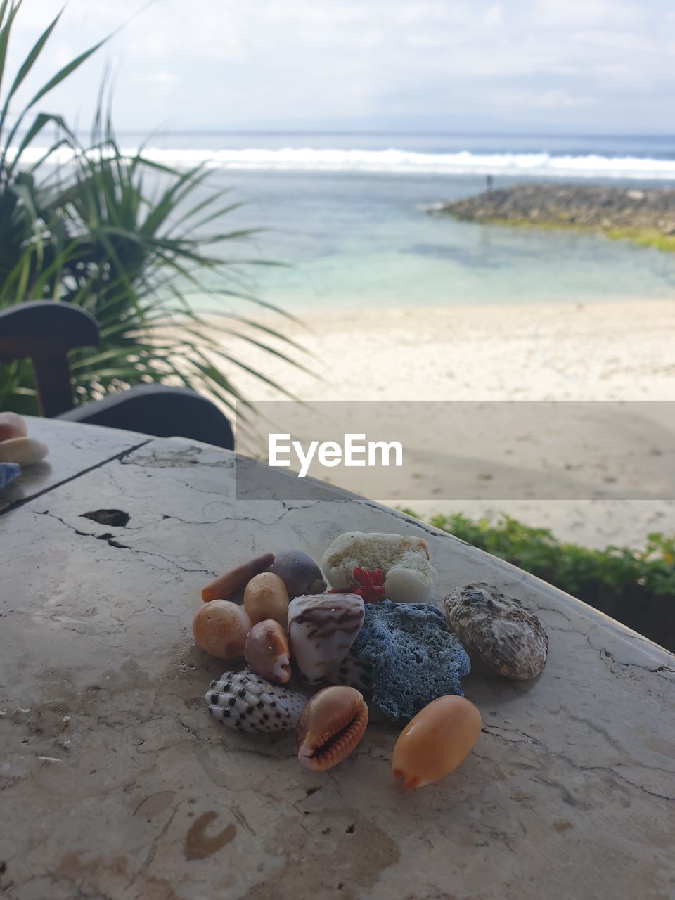 Rocks on shore at beach against sky