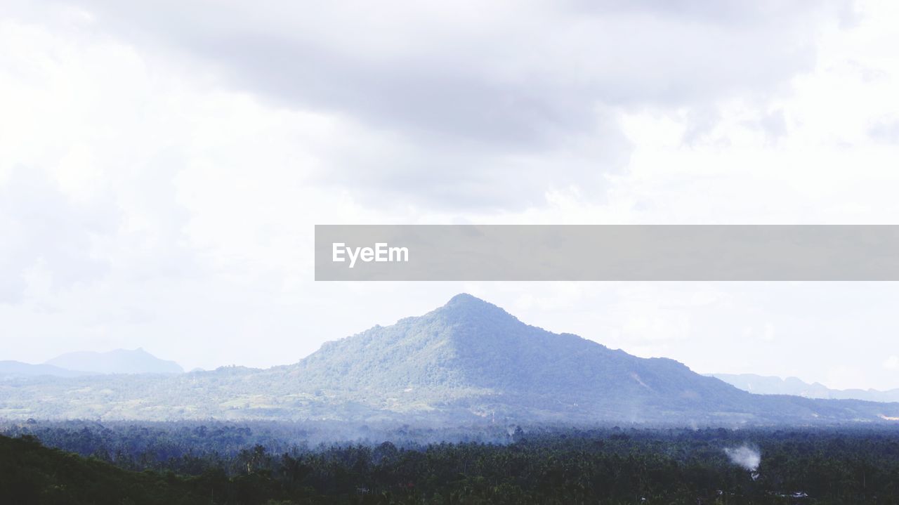 Scenic view of mountains against cloudy sky