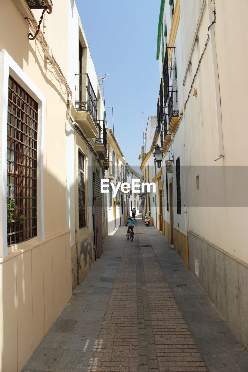 ALLEY AMIDST BUILDINGS IN CITY