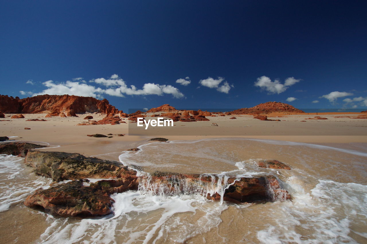 PANORAMIC SHOT OF ROCKS ON LAND AGAINST SKY