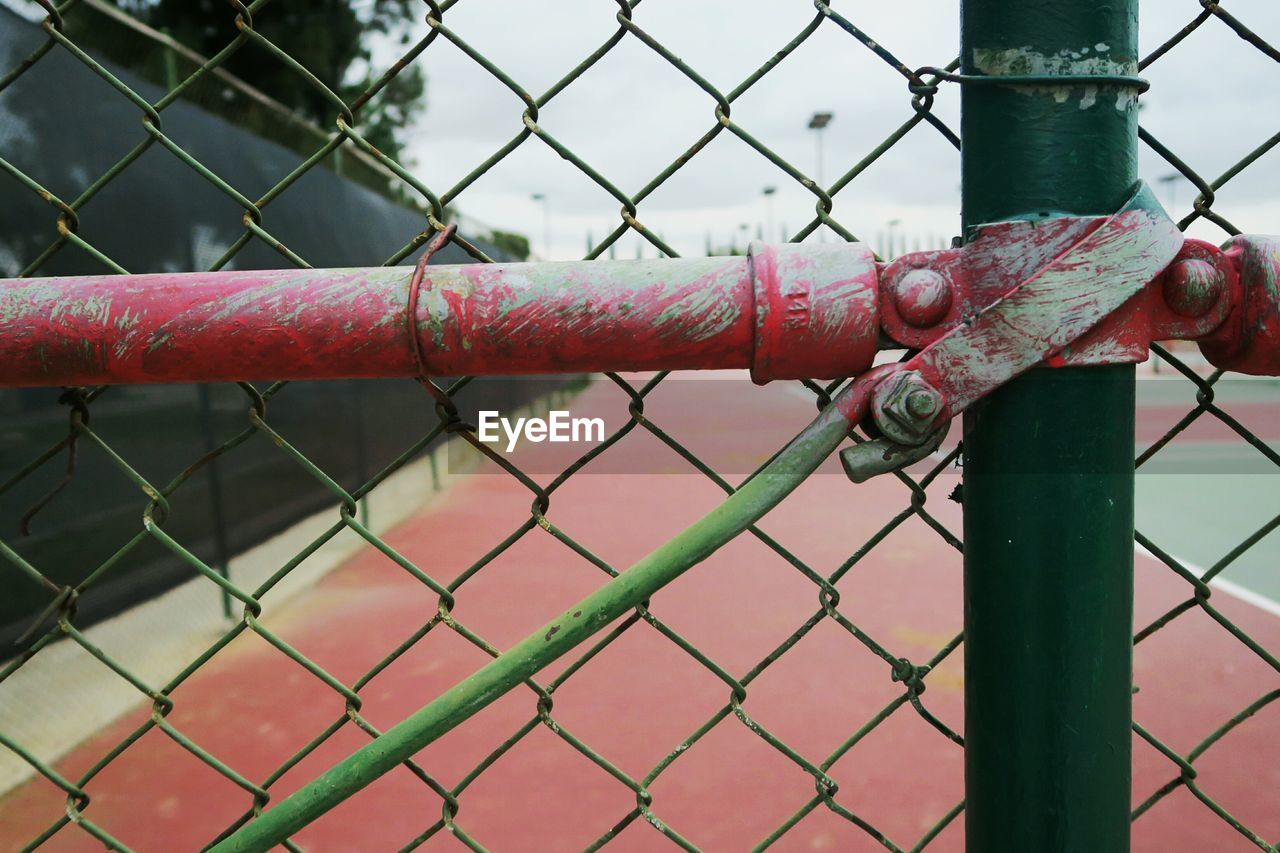 Close-up of fence at tennis court