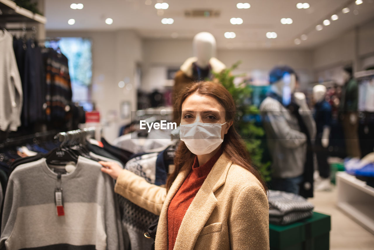 Woman wearing mask while looking at garments