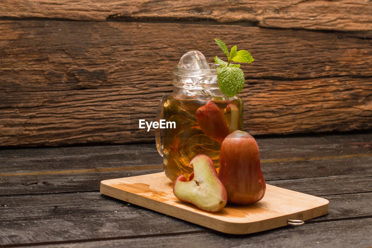 Drink in mason jar and water apple on cutting board