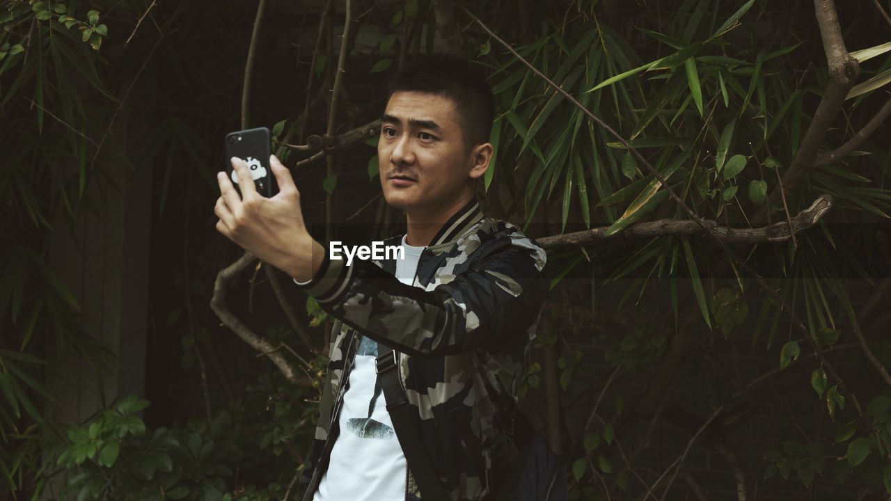 YOUNG MAN PHOTOGRAPHING WITH CAMERA