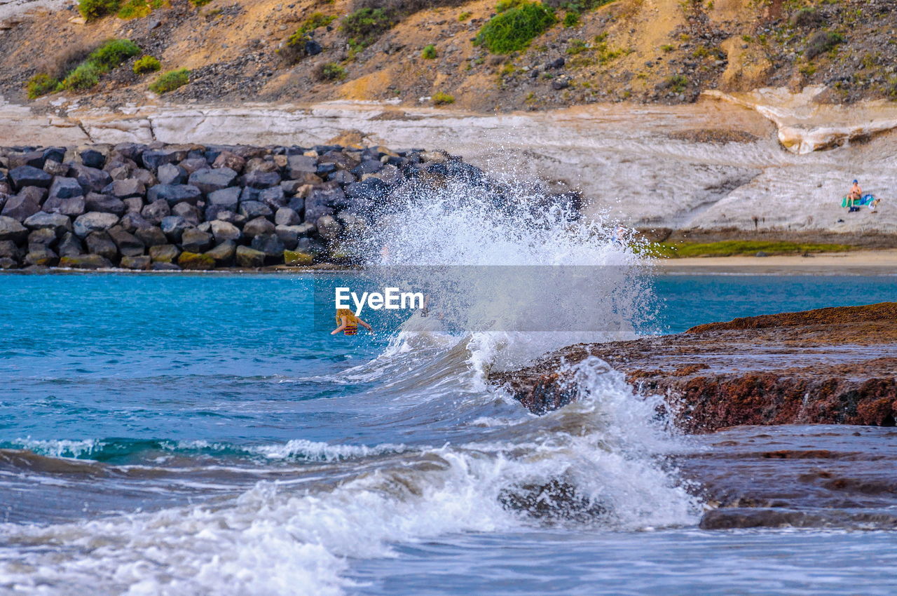 WAVES SPLASHING ON ROCKS AT BEACH