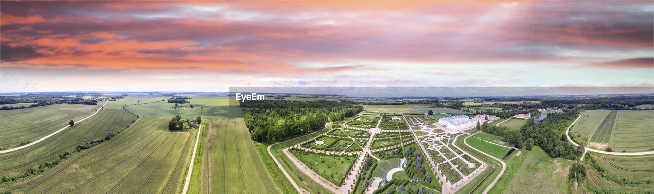 HIGH ANGLE VIEW OF ROAD AMIDST FIELD AGAINST SKY