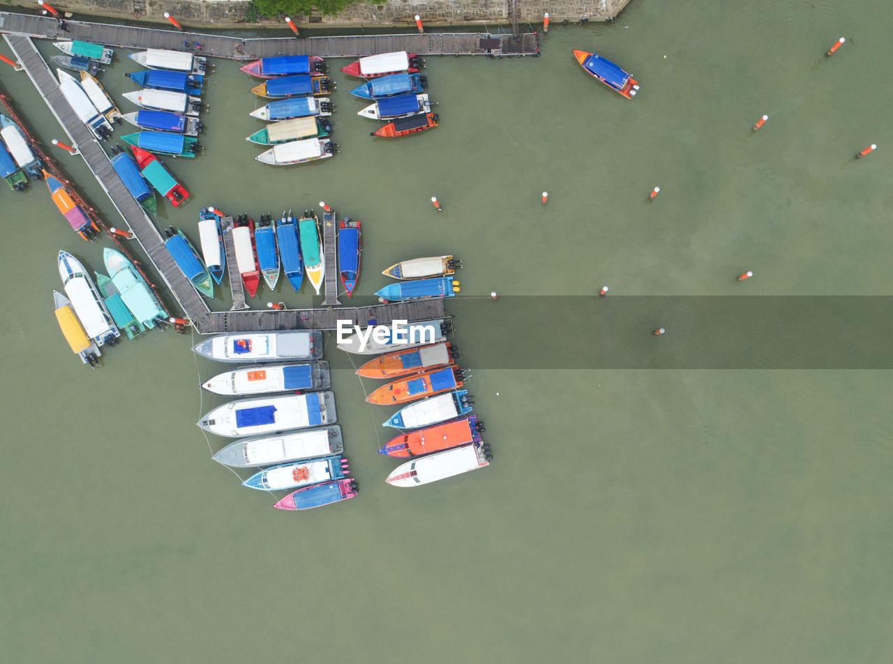 HIGH ANGLE VIEW OF MULTI COLORED BOATS MOORED AT SHORE