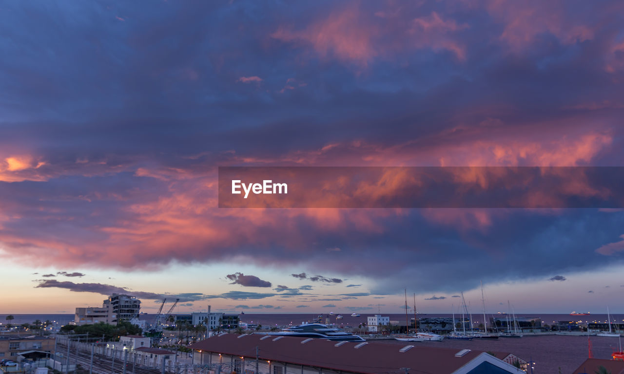 Panoramic view of buildings against dramatic sky during sunset