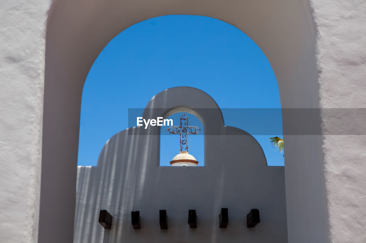 Low angle view of bell tower against blue sky