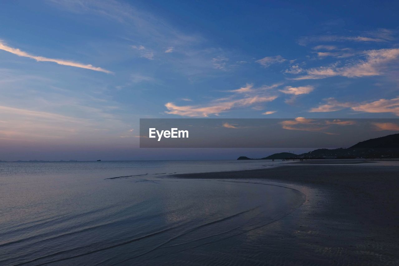 SCENIC VIEW OF BEACH AGAINST SKY AT SUNSET