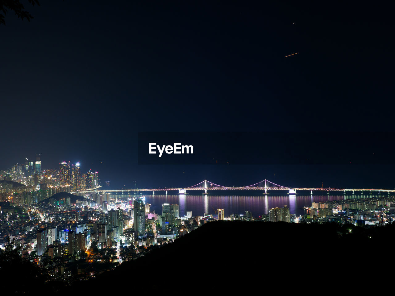 Illuminated modern buildings against sky at night