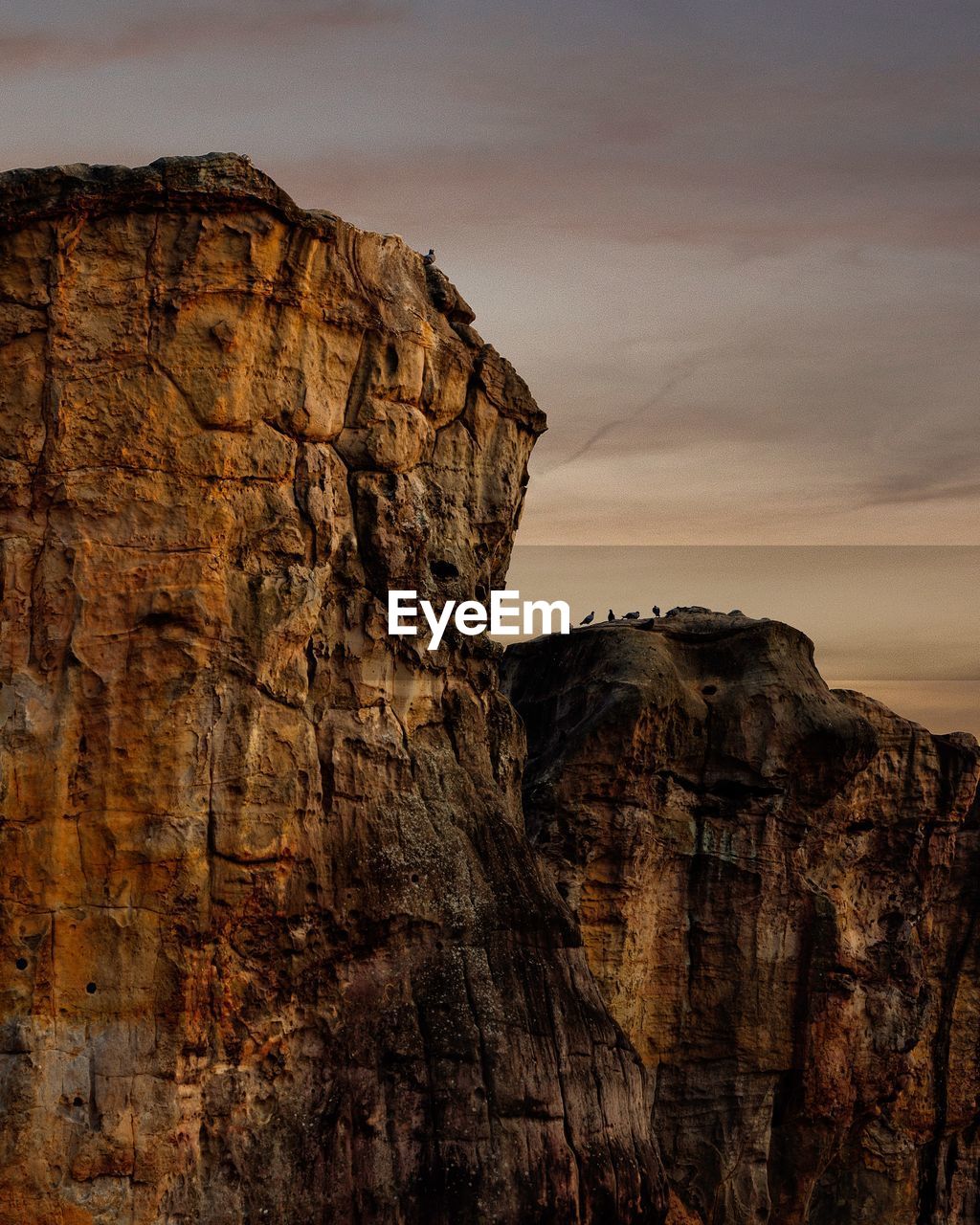 ROCK FORMATIONS ON CLIFF AGAINST SKY