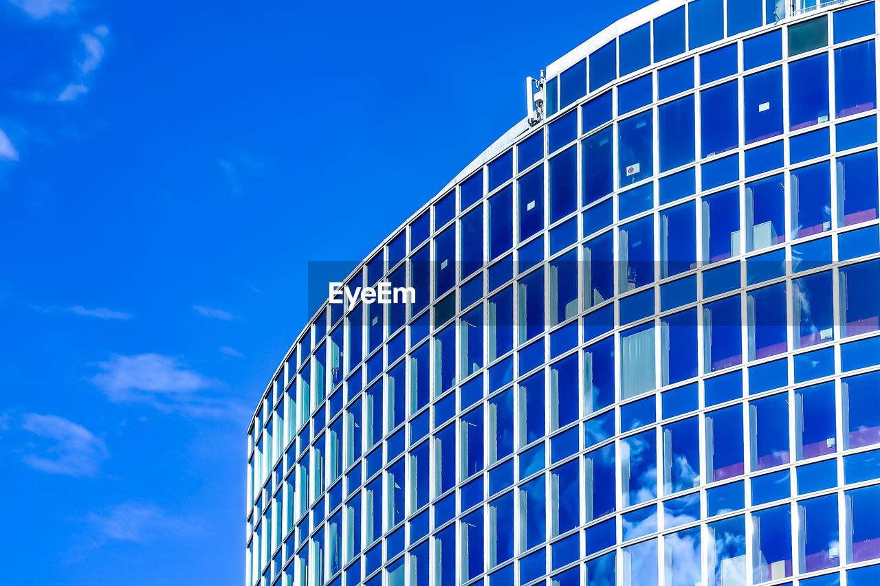 Low angle view of modern building against blue sky