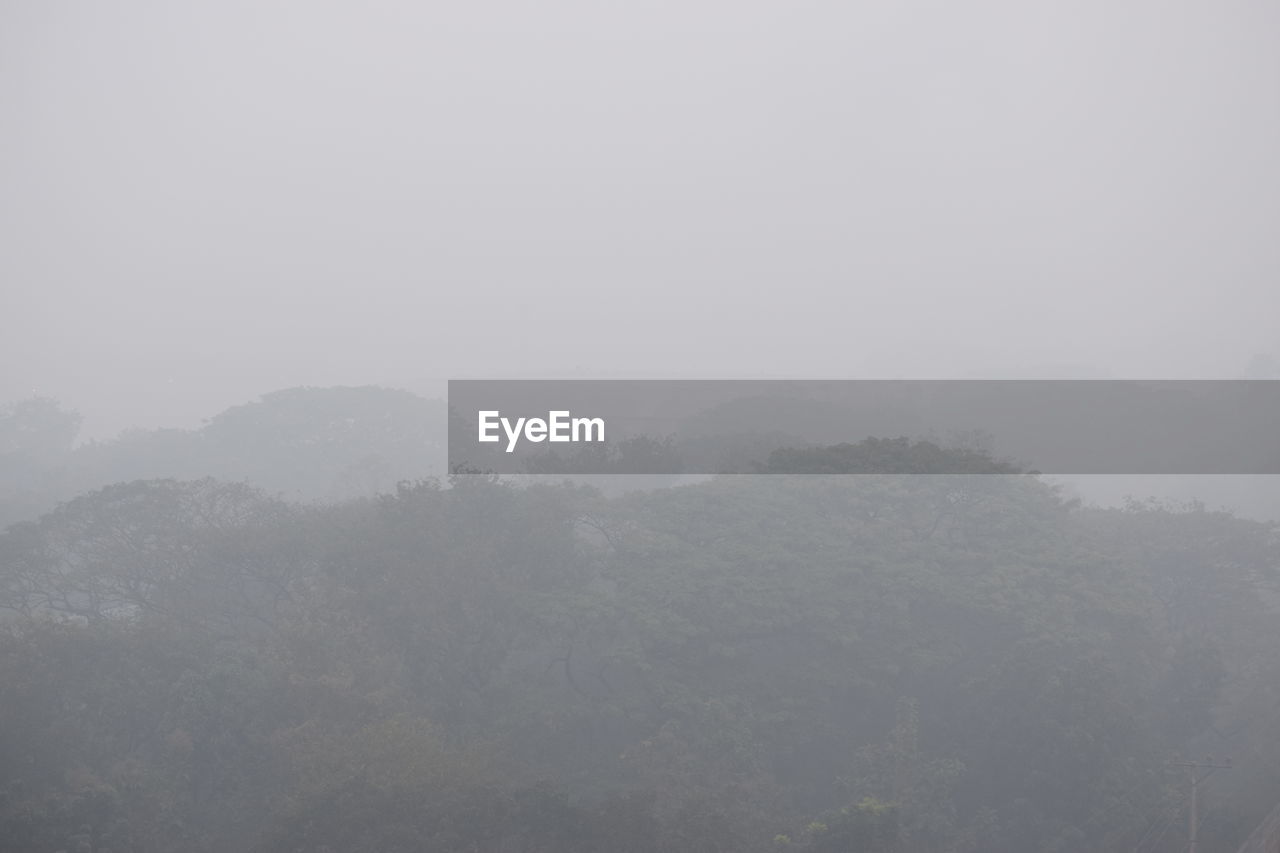 SCENIC VIEW OF MOUNTAINS IN FOGGY WEATHER AGAINST SKY