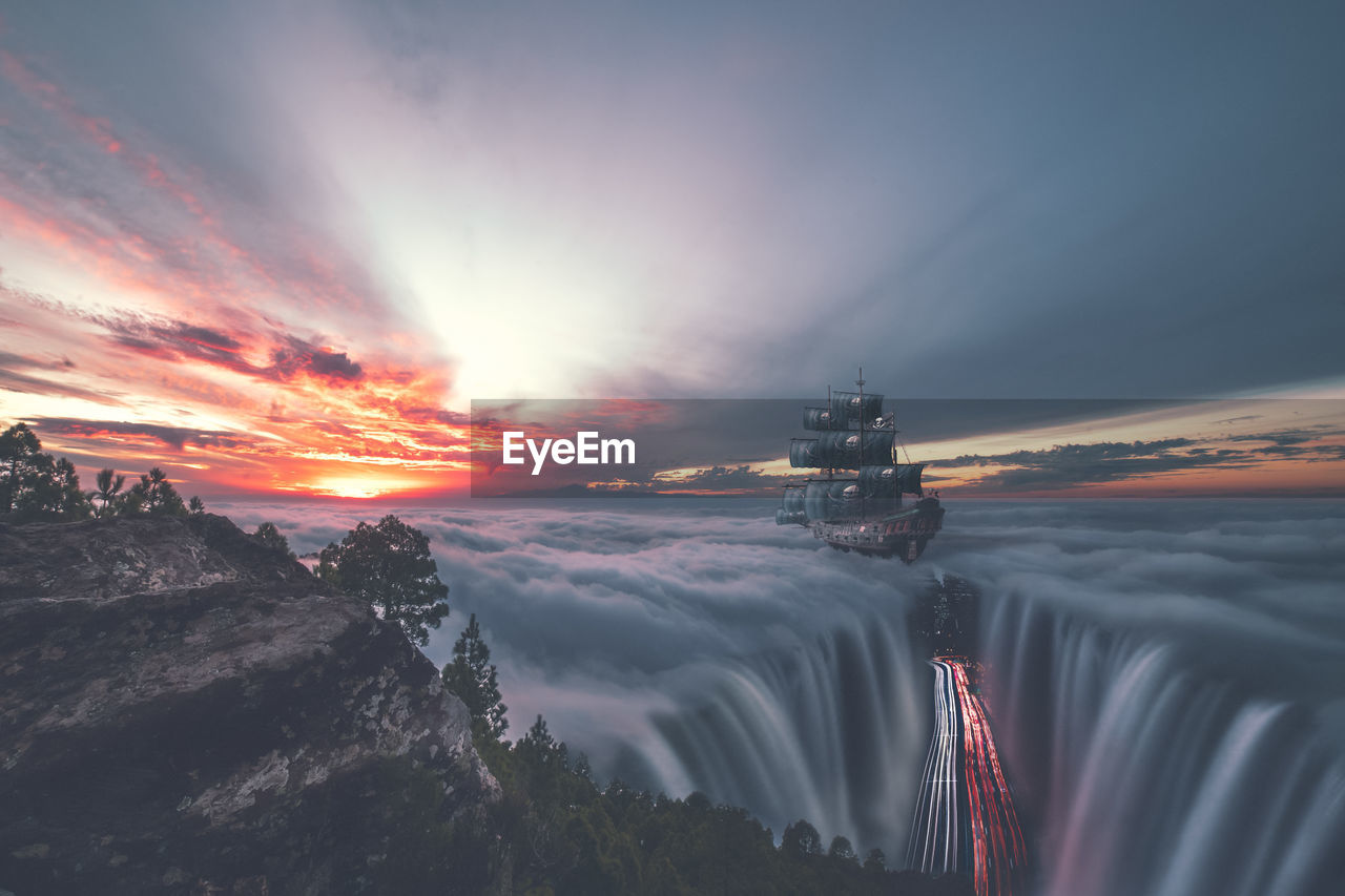 Digital composite image of waterfall and road against cloudy sky at sunset