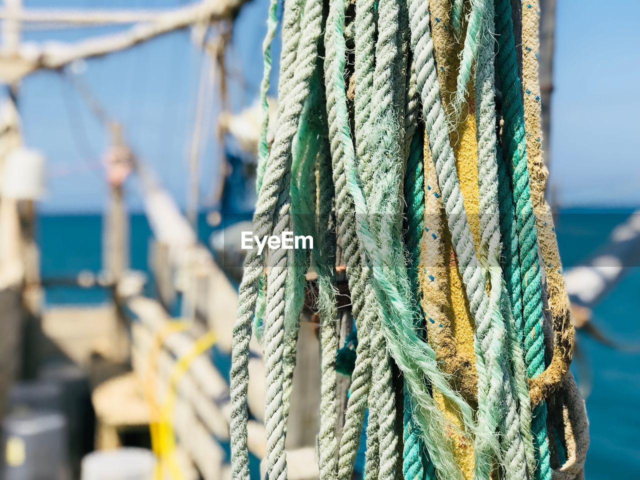 Ropes tied to pole against sea