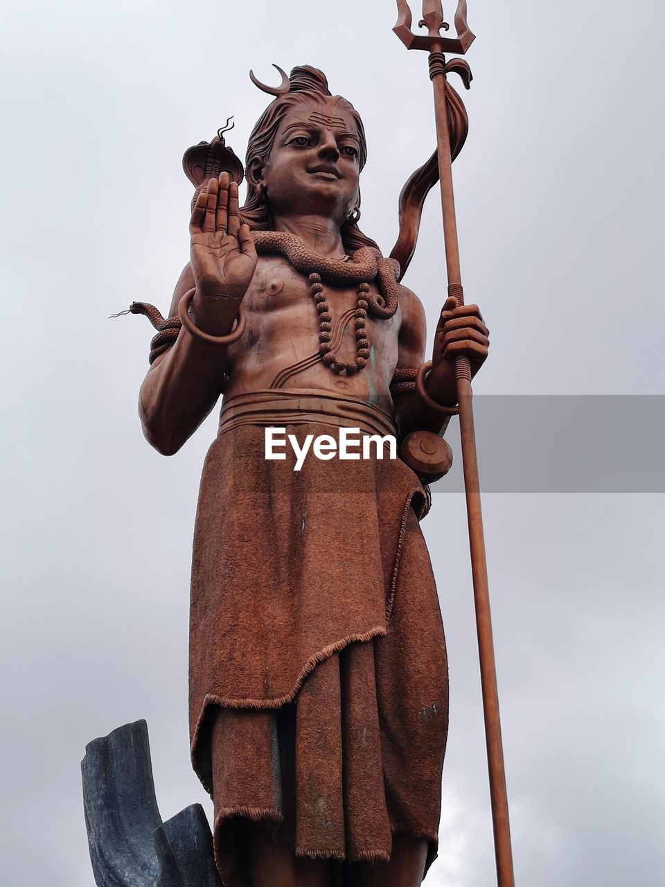 Low angle view of shiva statue against clear sky