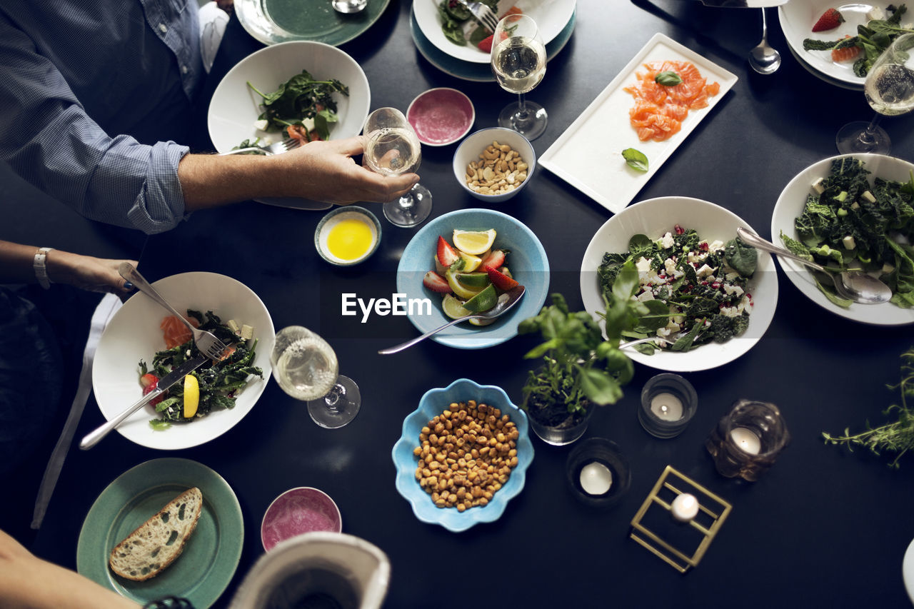 Cropped image of friends eating food at table