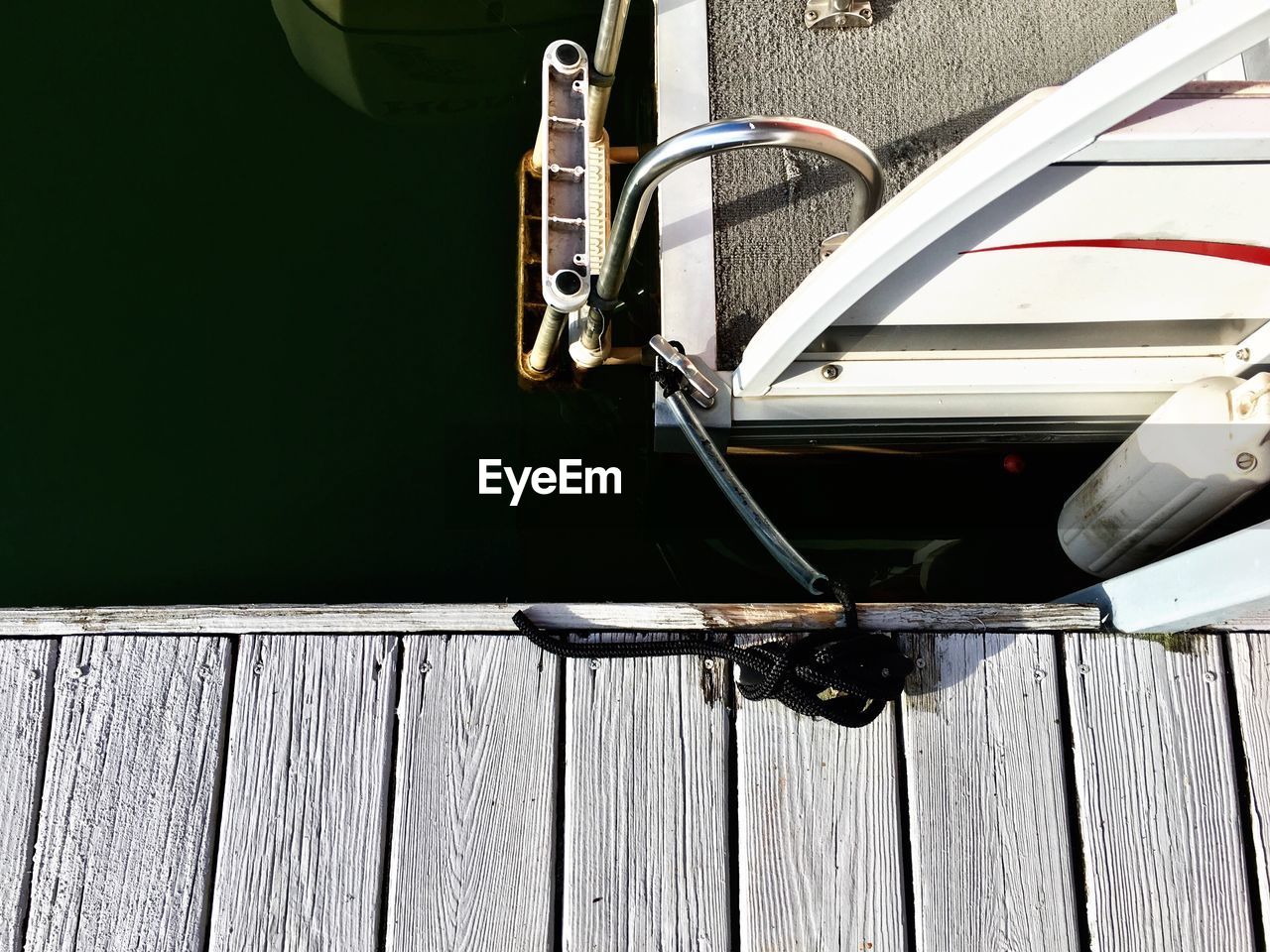 Cropped image of boat tied to jetty
