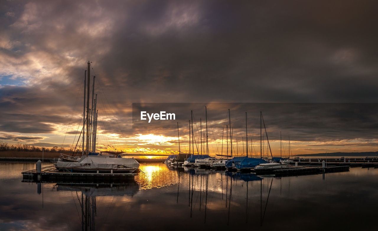 SAILBOATS MOORED AT HARBOR